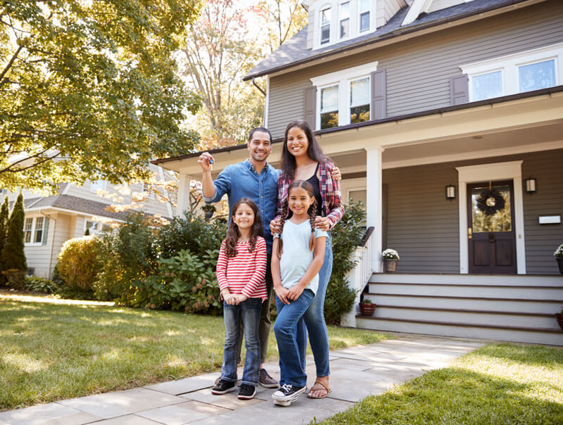 Happy family holding keys outside their home, representing clients protected across our Metro Detroit service areas.